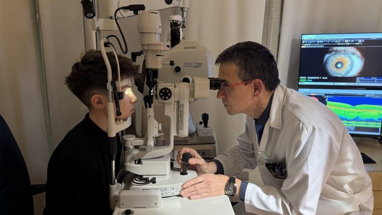 Joven atleta en consulta óptica con un optometrista realizando un examen ocular