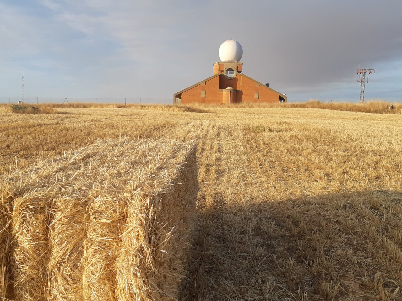 Campo de cultivo con heno y edificio en Aguilar de Campoo