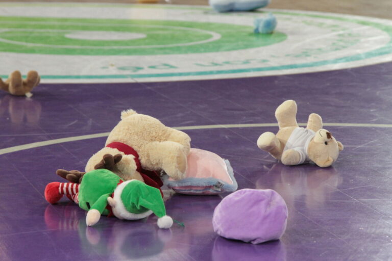 Peluches de navidad en el suelo de una cancha de baloncesto