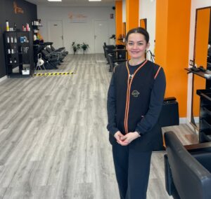 Interior de una peluquería low cost con estilista sonriente