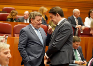 Dos políticos conversando en el pleno de las Cortes de Castilla y León.