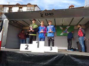 Tres jóvenes atletas en el podio con medallas en Castro Urdiales