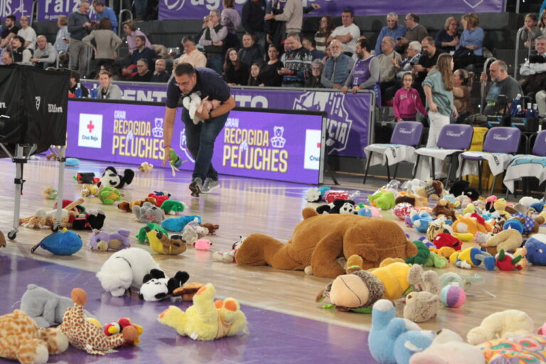 Un hombre recoge peluches en la cancha de baloncesto durante un evento