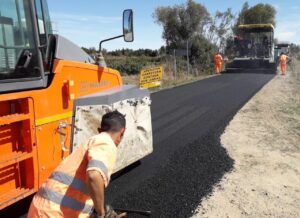 Trabajadores asfaltando carretera en Palencia con maquinaria pesada