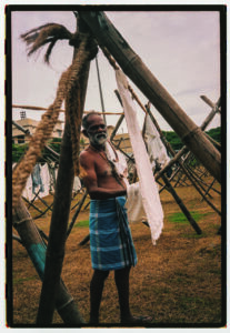 Hombre mayor en un entorno de lavandería tradicional al aire libre