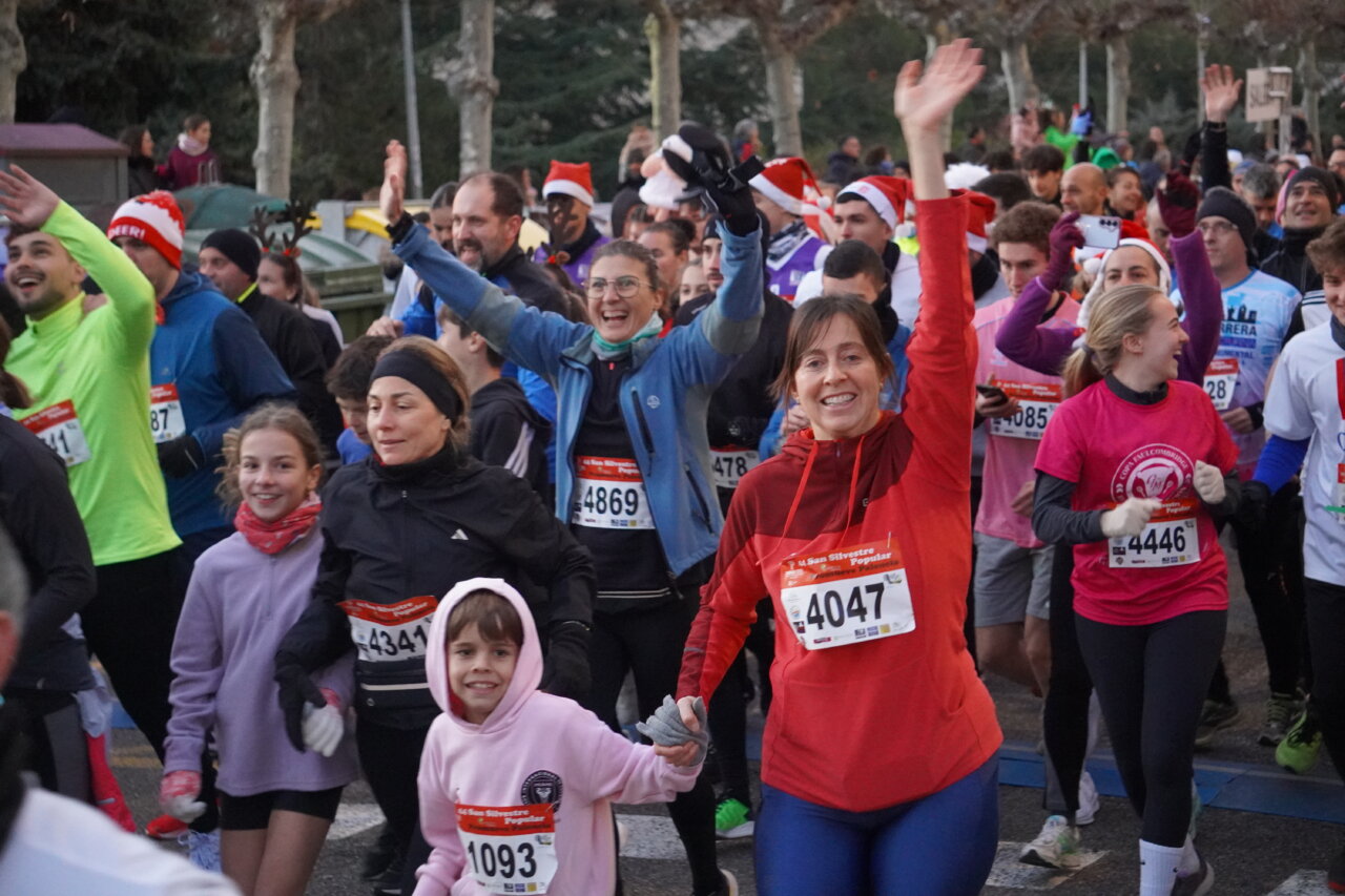 Corredores en la San Silvestre Palentina levantando las manos y sonriendo.