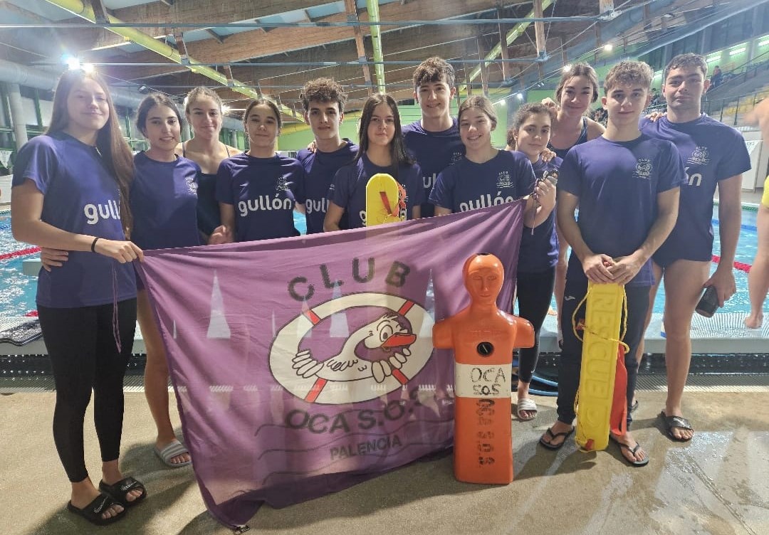 Equipo del Club Oca SOS posando con medallas y banderas en la piscina