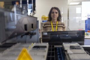 Mujer en laboratorio de medicina personalizada con tecnología avanzada