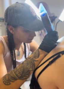Artista de tatuajes trabajando en un diseño de tatuaje plateado