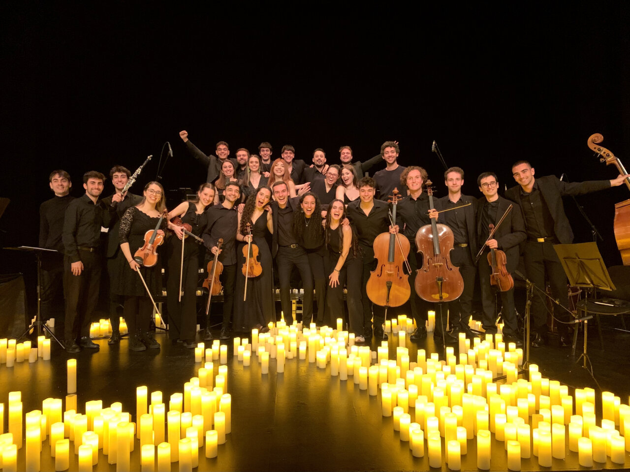 Músicos de la Orquesta y Coro de Cámara SONORA en un escenario iluminado con velas