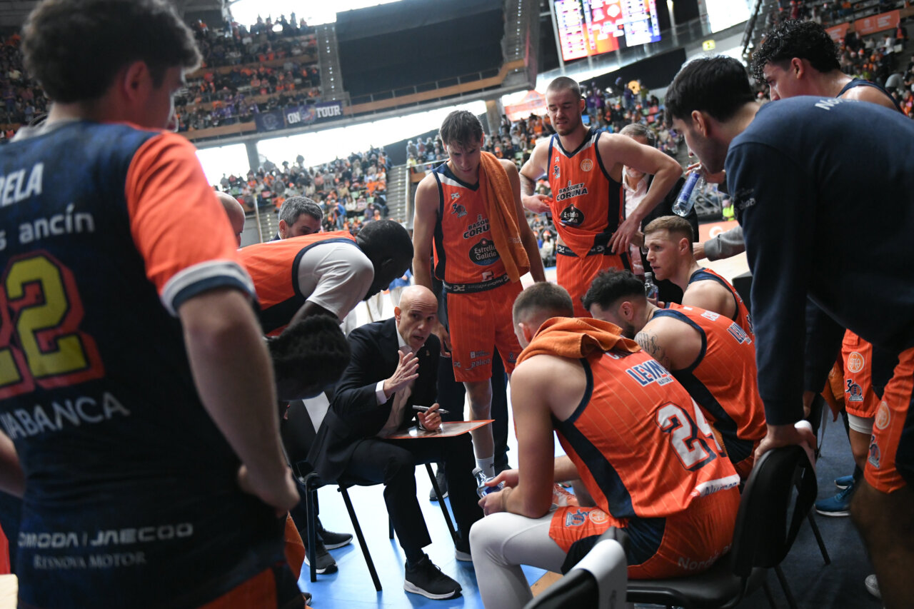 Entrenador del Leyma Coruña dirigiendo a su equipo durante un partido de baloncesto.