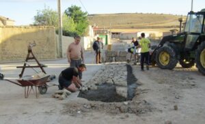 Trabajadores realizando labores de construcción en una calle rural