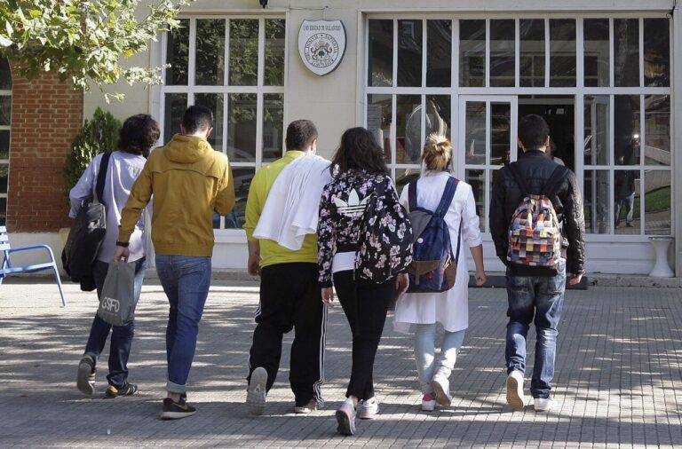 Grupo de jóvenes universitarios caminando hacia un edificio educativo