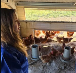 Vanesa Urizarna Núñez observando gallinas en su granja sostenible