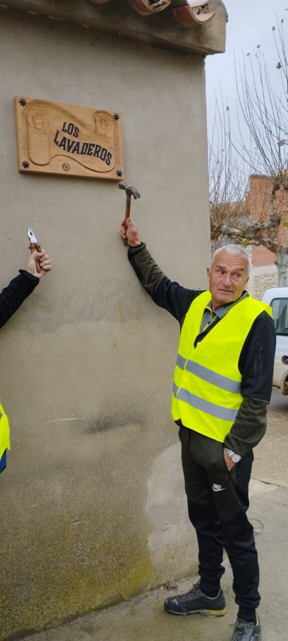 Voluntarios colocando un cartel en Villamediana durante la Navidad