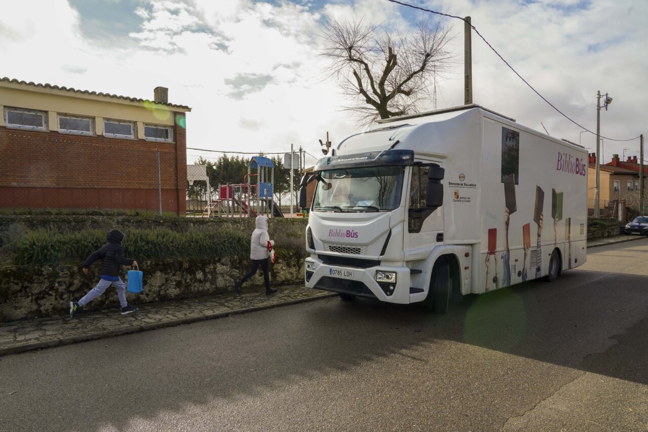 Bibliobús estacionado en Villalba de los Alcores con niños acercándose.