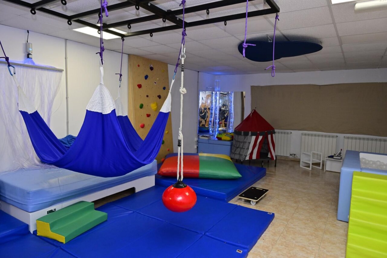 Interior del centro multiservicios con áreas de rehabilitación y terapia.