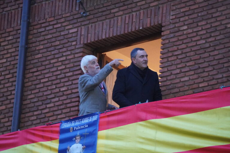 Dos hombres observando desde un balcón durante un evento en Palencia.