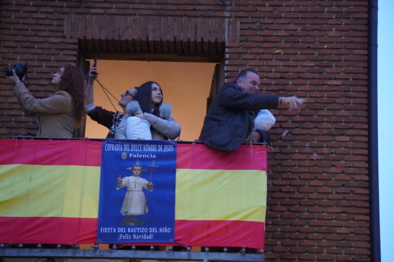 Personas en un balcón durante la fiesta del bautizo del niño en Palencia.