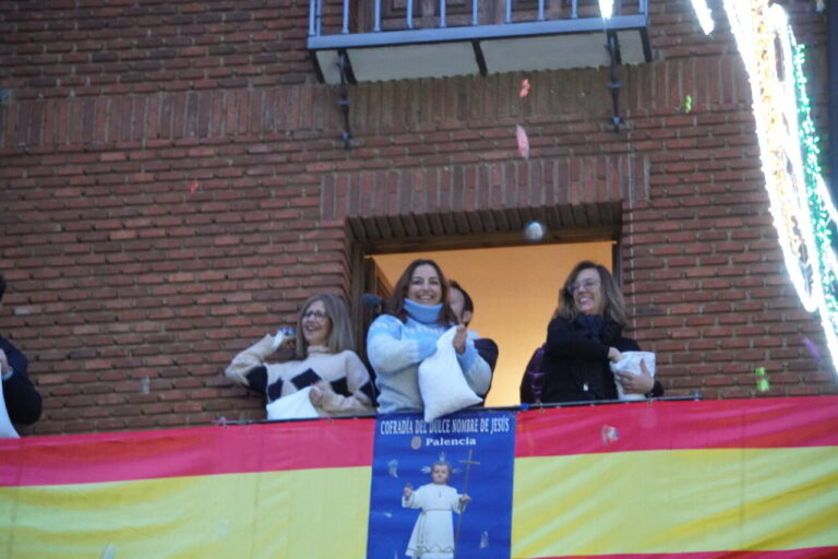 Celebración del bautizo con personas lanzando confeti desde un balcón