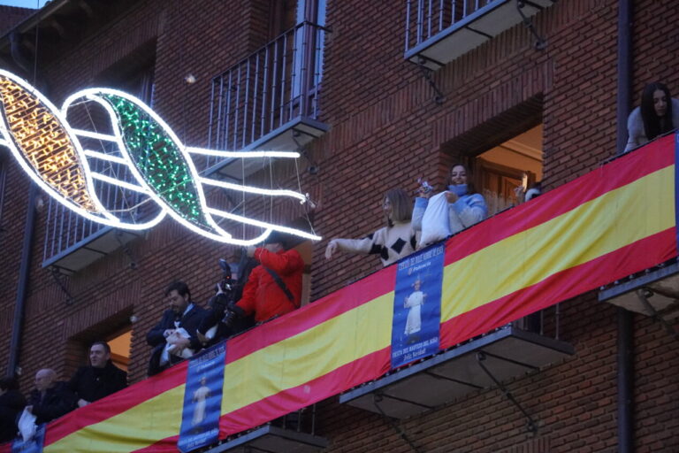 Celebración del bautizo con decoraciones y asistentes en el balcón