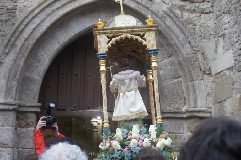 Estatua del niño en un bautizo con flores blancas