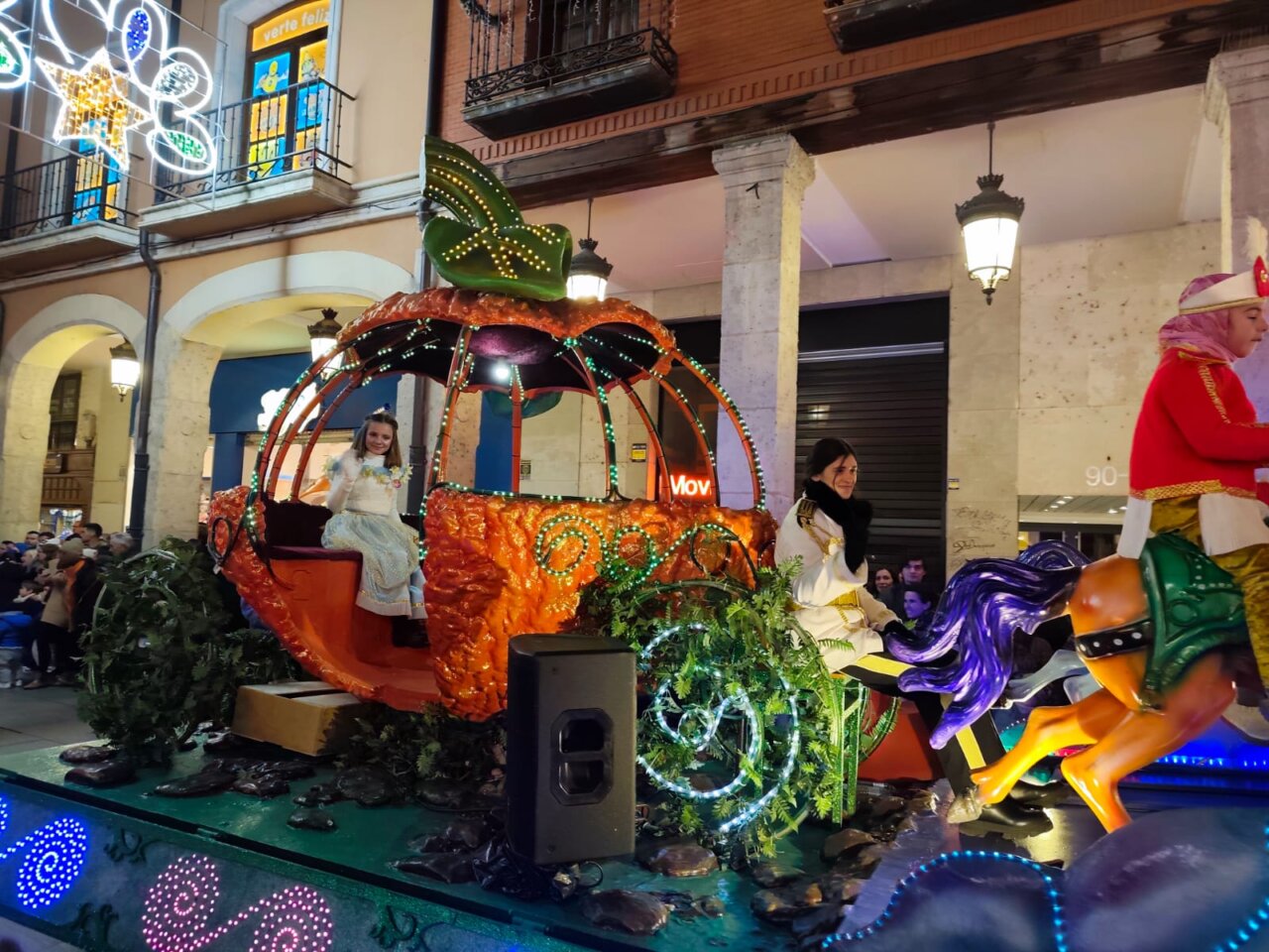 Carroza de la cabalgata de Reyes en Palencia con una niña y decoraciones coloridas