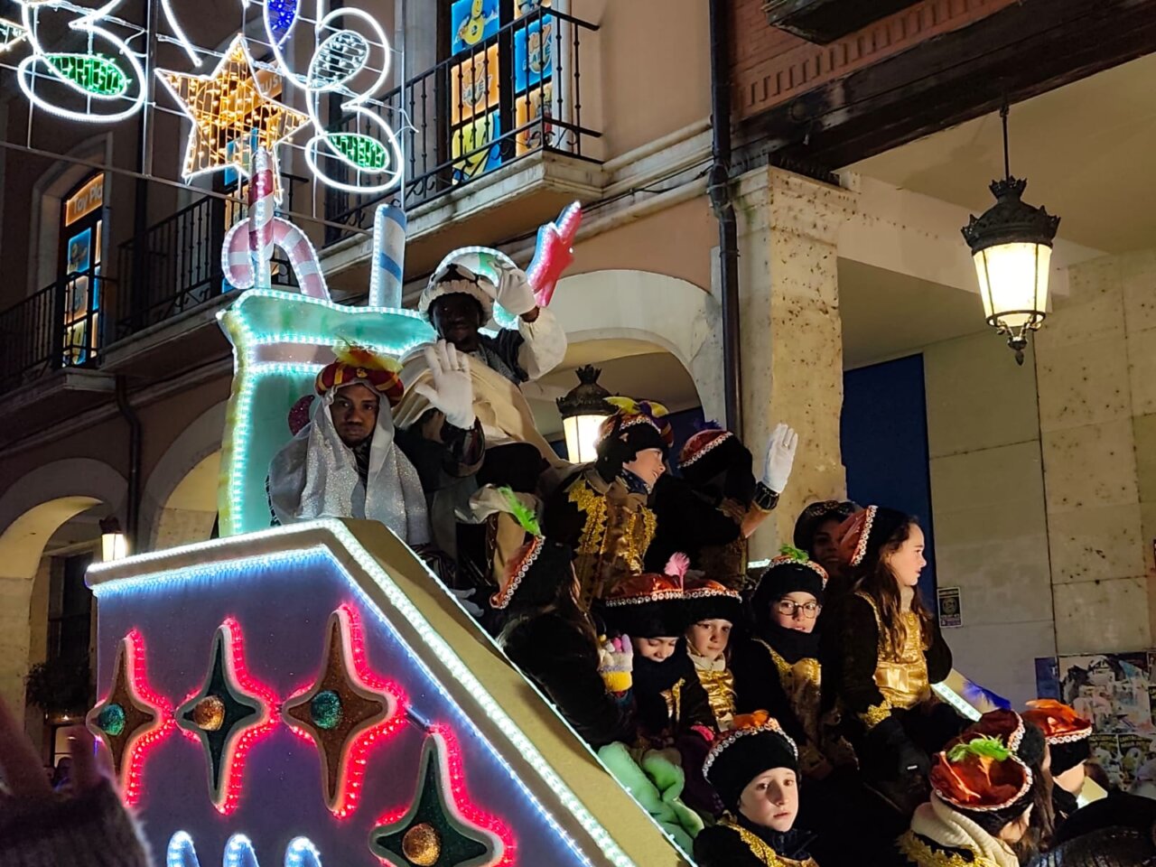 Participantes de la cabalgata de Reyes en Palencia saludando al público.