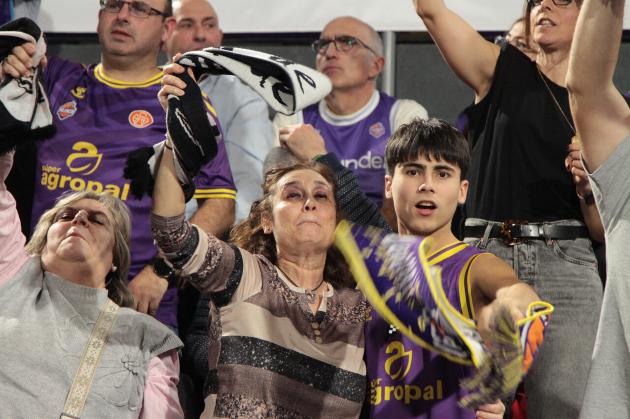 Aficionados animando en las gradas de un partido de baloncesto