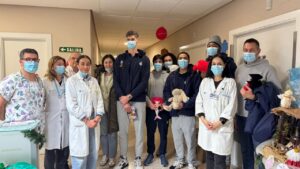 Jugadores y personal del hospital con peluches en mano