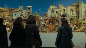 Visitantes observando un belén en una exposición navideña