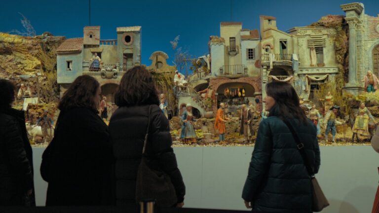Visitantes observando un belén en una exposición navideña