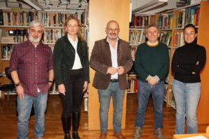 Grupo de personas en una biblioteca discutiendo acuerdos culturales