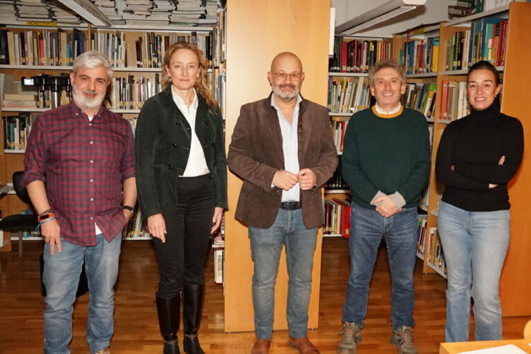 Grupo de personas en una biblioteca discutiendo acuerdos culturales