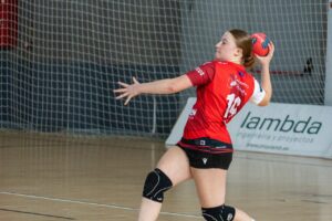 Jugadora del Odisea lanzando un balón de balonmano durante un partido
