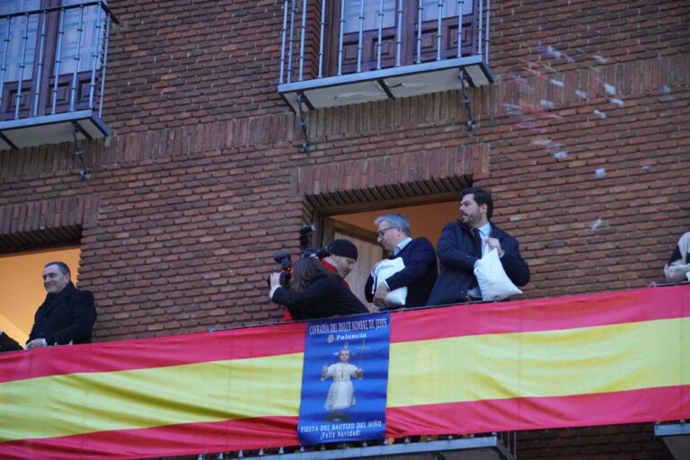 Celebración del bautizo del niño en San Miguel con personas en el balcón