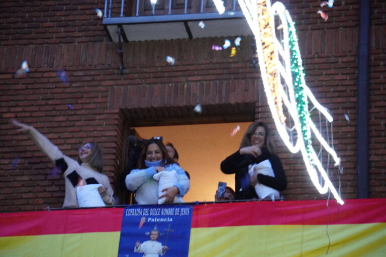 Celebración del bautizo con confeti y personas en el balcón