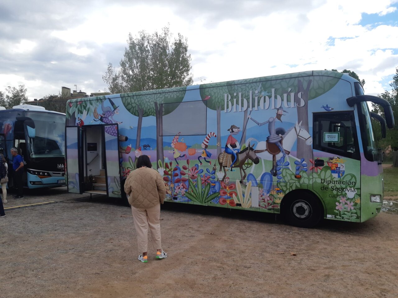 Bibliobús decorado con ilustraciones en un entorno rural