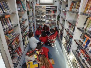 Niños disfrutando de la lectura en el interior de un bibliobús en Villalba de los Alcores.