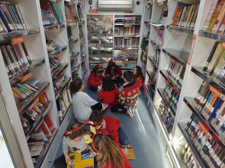 Niños disfrutando de la lectura en el interior de un bibliobús en Villalba de los Alcores.