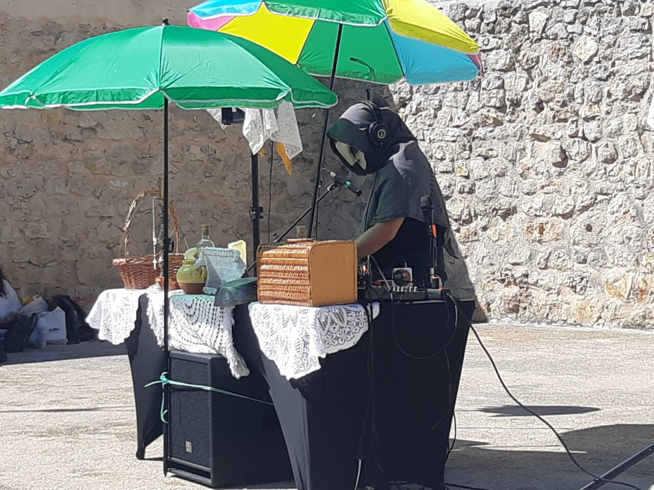 Artista Castora Herz actuando en un evento al aire libre con sombrillas