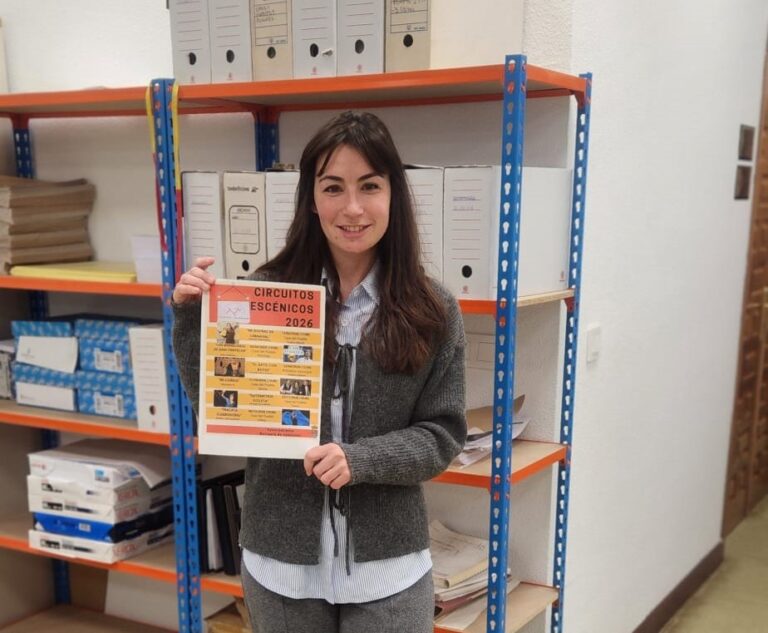 Mujer sosteniendo un cartel de Circuitos Escénicos 2026 en una oficina