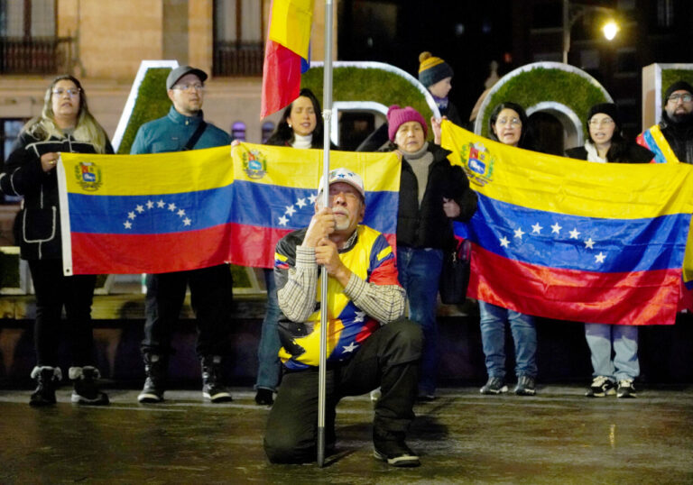 Venezolanos en Valladolid sosteniendo banderas durante una concentración