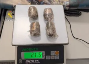 Cuatro envoltorios de hachís pesando 211 gramos en una balanza