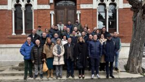 Grupo de personas posando frente a un edificio de ladrillo