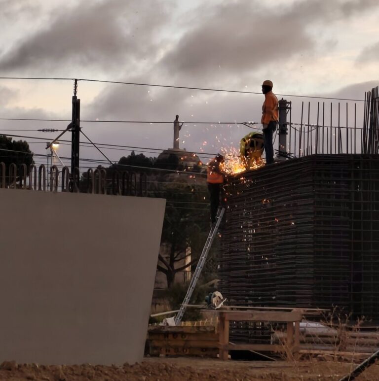 Trabajadores en una obra de construcción con chispas volando