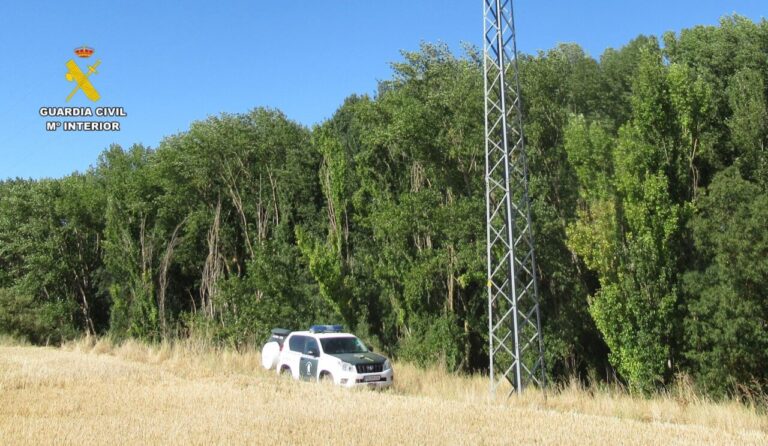 Vehículo de la Guardia Civil junto a una línea eléctrica en Torquemada