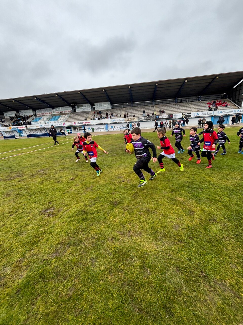Un jugador sub-8 corre hacia el ensayo en un partido de rugby en Aranda.
