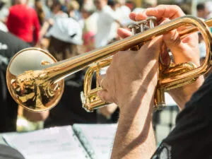 Mano sosteniendo una trompeta en un evento musical al aire libre