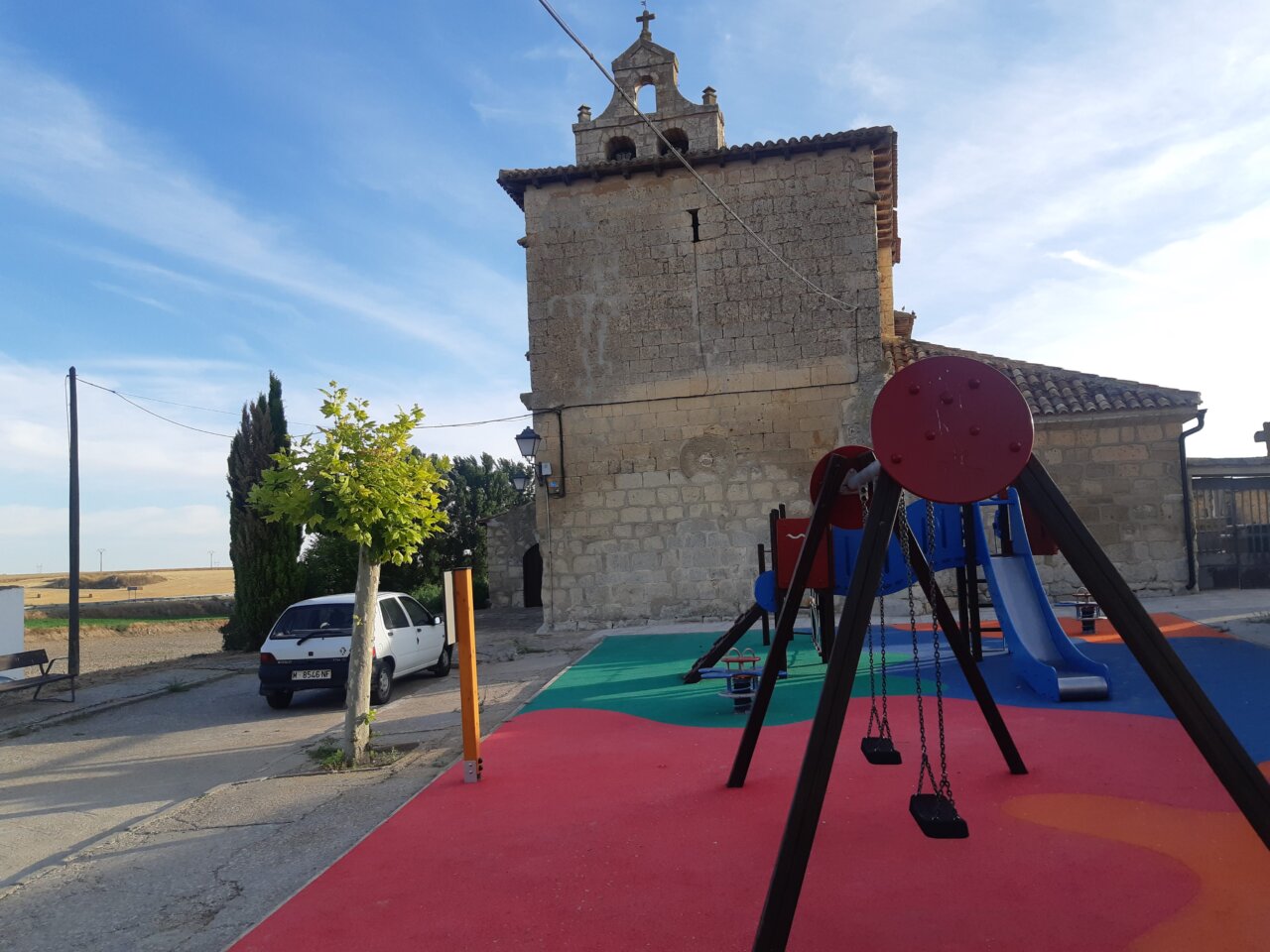 Parque infantil con columpios y toboganes en un entorno rural